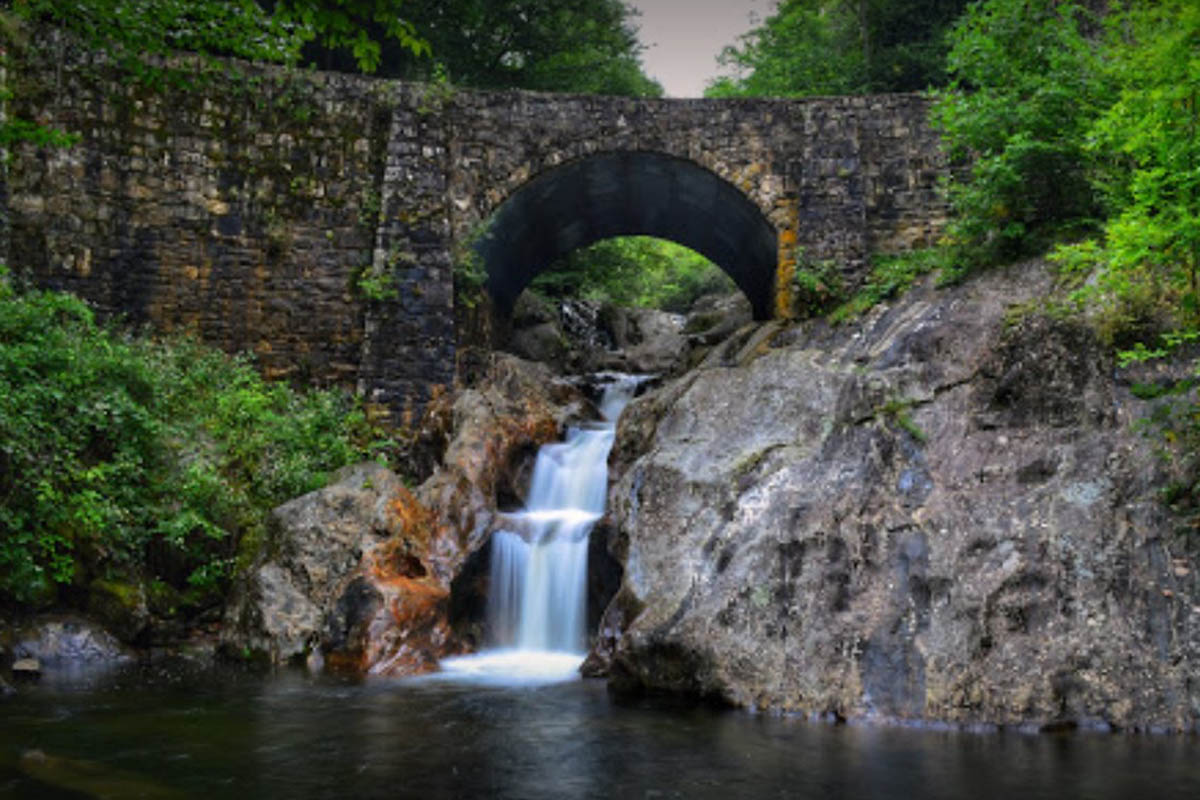 Sunburst Falls flowing beneath a stone bridge in Pisgah National Forest, North Carolina
