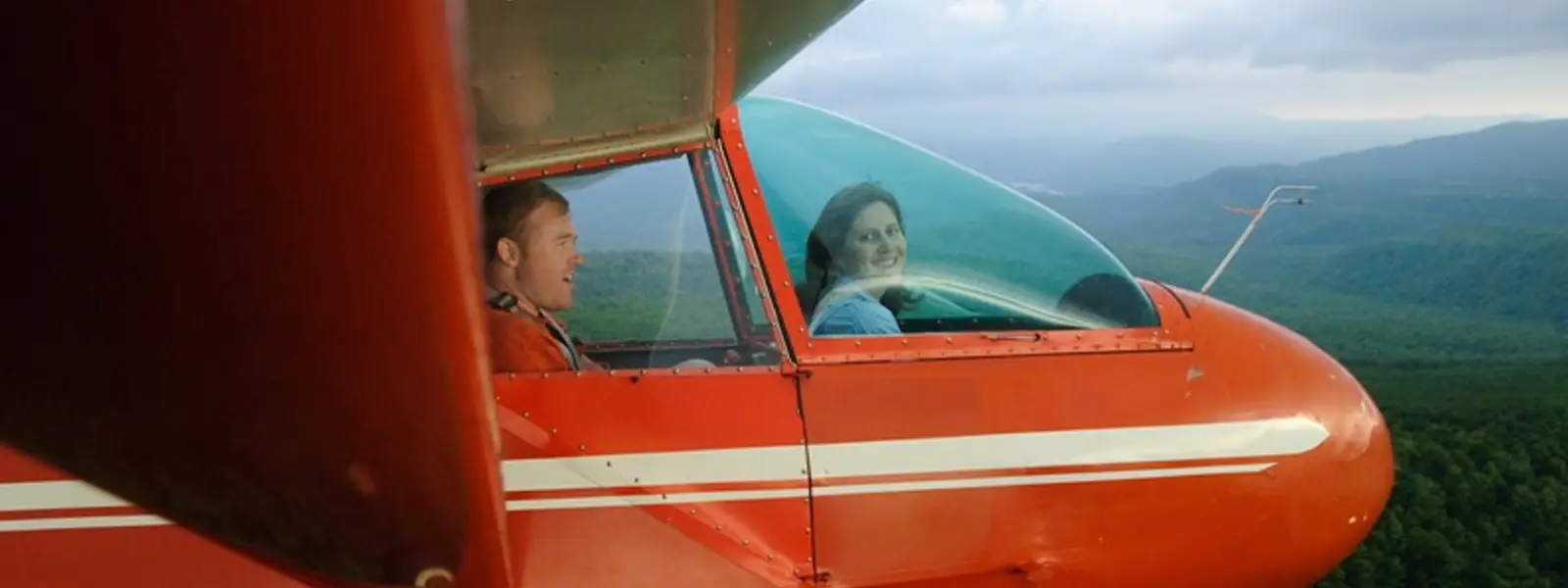 Small plane flying above the Ocoee River and mountain landscape