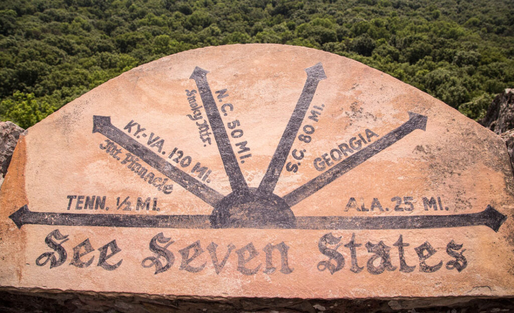 Directional marker engraved into stone pointing to seven U.S. states