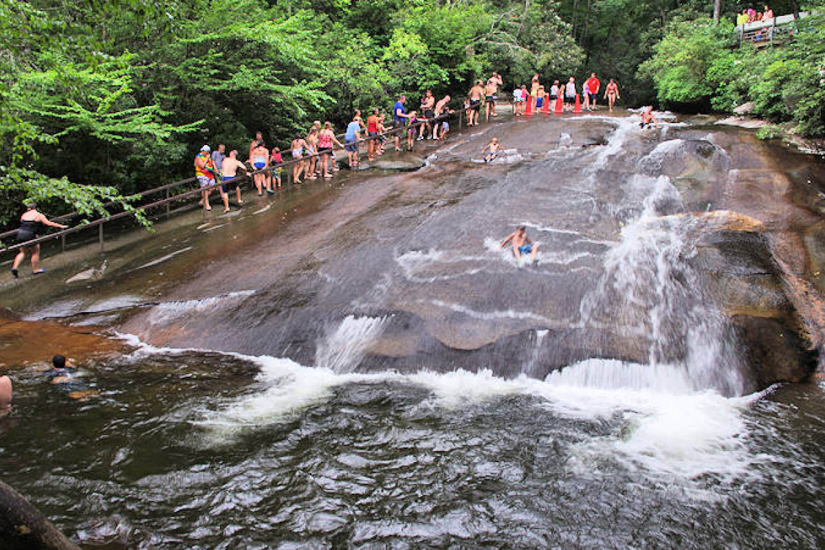 Visitors sliding down the natural rock waterslide at Sliding Rock in Pisgah National Forest, North Carolina